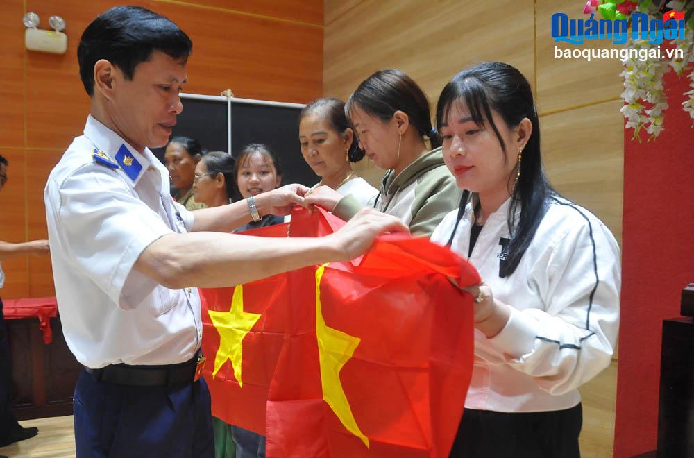 Đại tá Kiều Khánh Dũng – Chủ nhiệm Chính trị Vùng Cảnh sát biển 2 tặng cờ Tổ quốc cho ngư dân Lý Sơn. 
