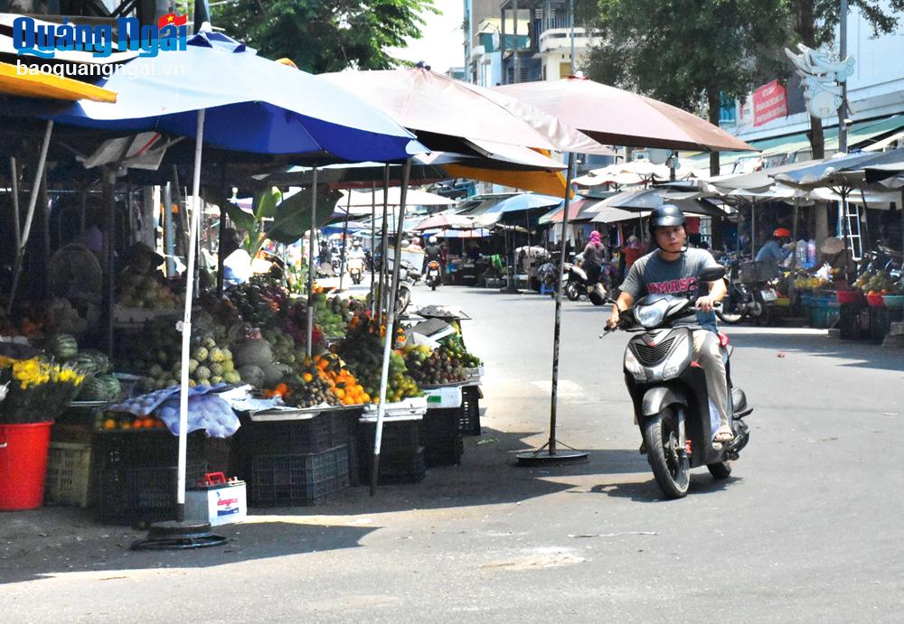 Các gian hàng trái cây lấn chiếm vỉa hè và một phần lòng đường ngay khu vực ngã ba Nguyễn Nghiêm - Ngô Quyền.