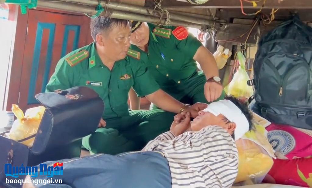Quân y Bộ đội Biên phòng hỗ trợ băng bó vết thương cho ngư dân bị nạn.