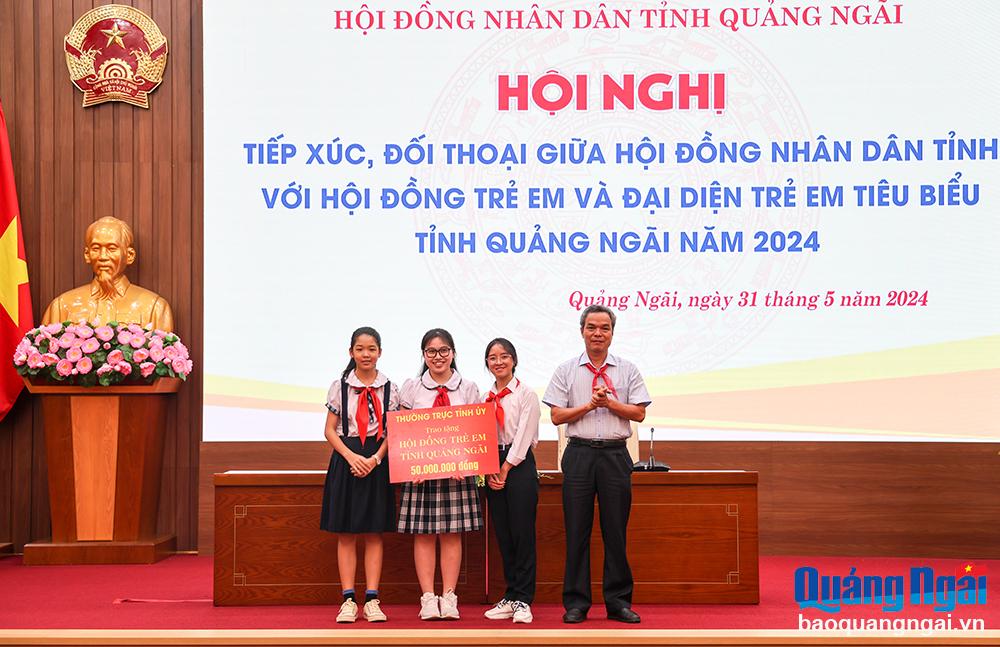 Trưởng ban Tuyên giáo Tỉnh ủy Đặng Ngọc Dũng trao bảng tượng trưng tặng 50 triệu đồng cho Hội đồng trẻ em tỉnh.