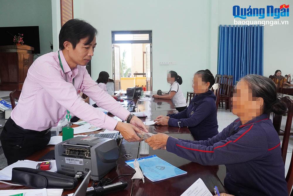 Cán bộ Phòng Giao dịch Ngân hàng Chính sách xã hội huyện Bình Sơn  giải  ngân vốn cho gia đình người chấp hành xong án phạt tù phát triển kinh tế.					    	                                                                               Ảnh: PV
