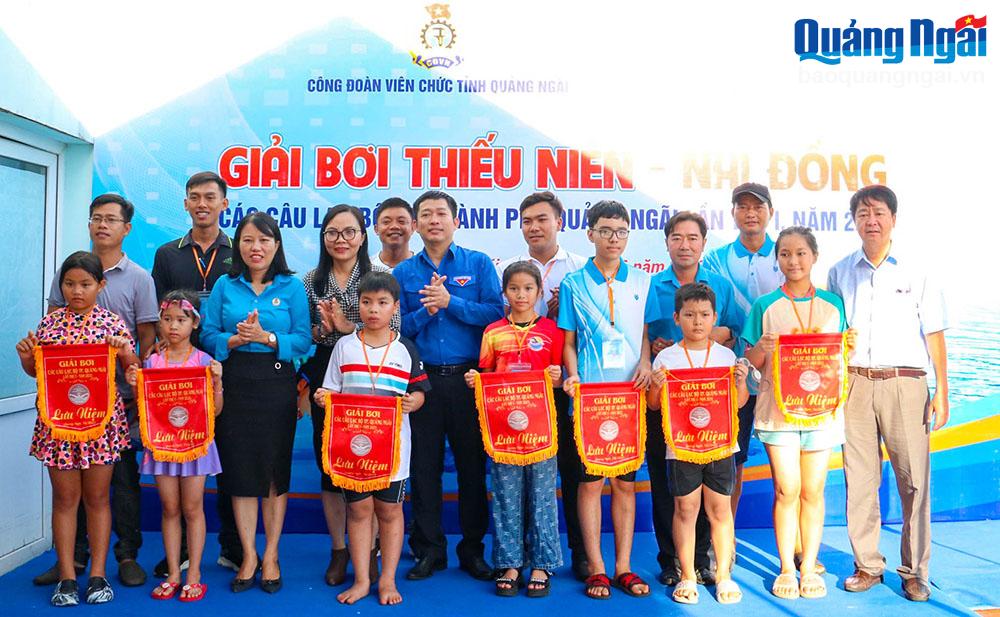 Ban tổ chức trao cờ lưu niệm cho đại diện các câu lạc bộ tham gia thi giải bơi.