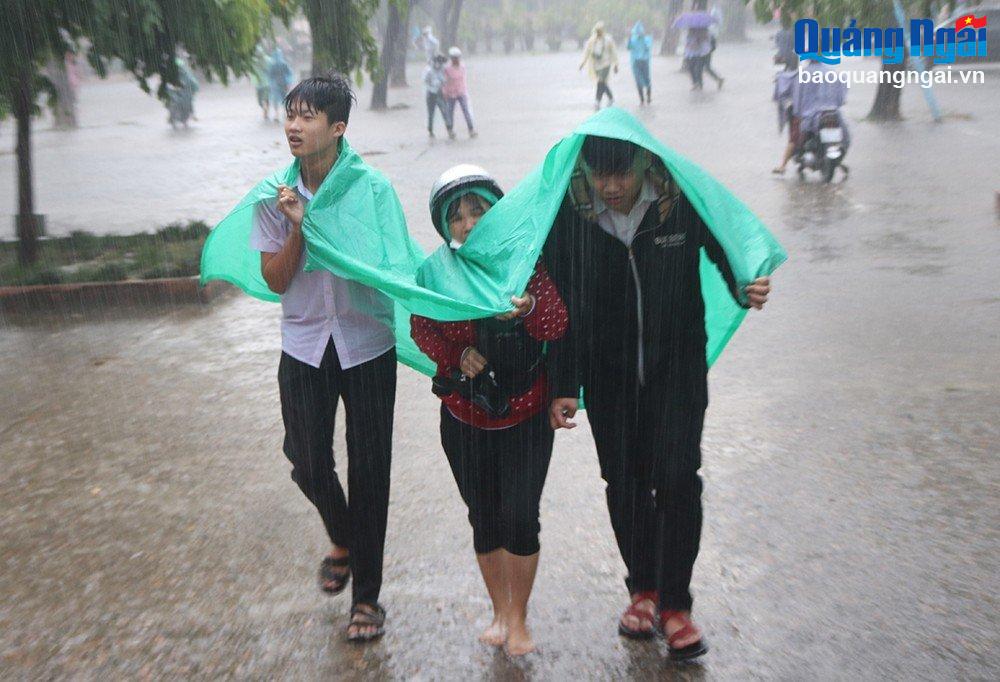 Thí sinh tại Hội đồng thi Trường THPT Chu Văn An (Tư Nghĩa) đội mưa về nhà sau khi hoàn thành môn Toán.
