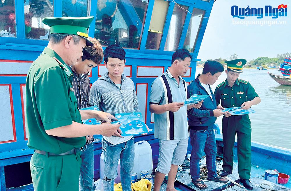 Cán bộ Trạm Kiểm soát biên phòng Bình Thanh (Bình Sơn) phát tờ rơi,
 tuyên truyền cho ngư dân các quy định chống khai thác IUU.