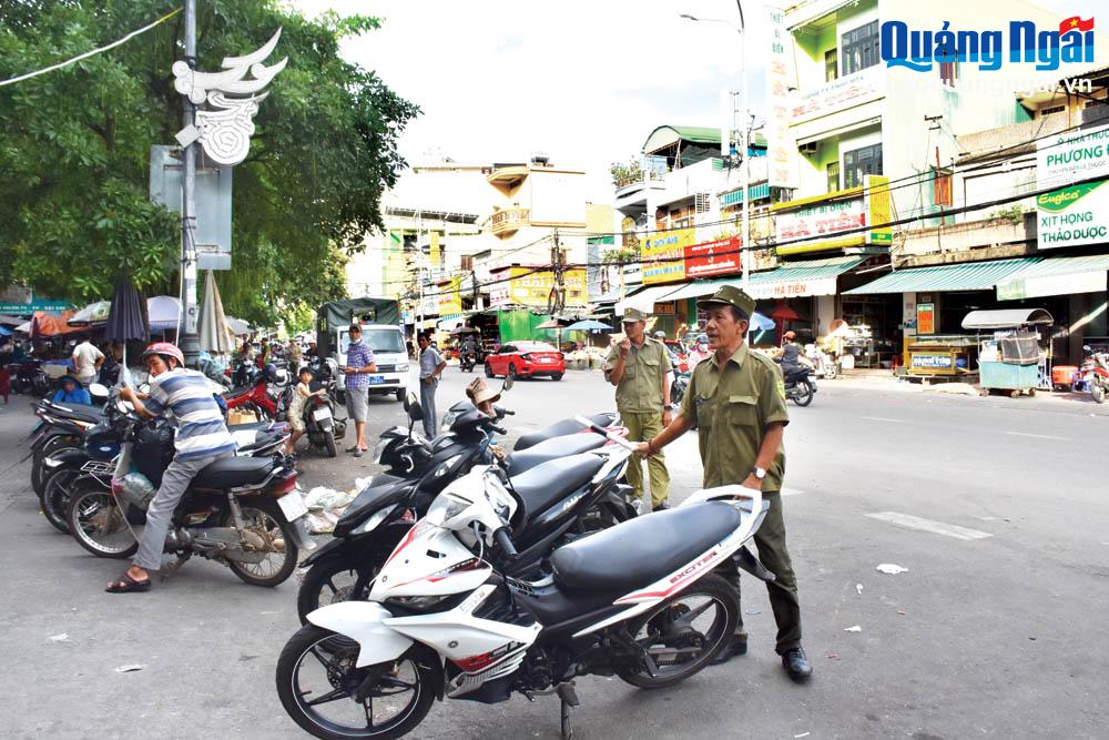 Thành phố Quảng Ngãi đang tập trung nhân lực để tuần tra, xử lý các phương tiện dừng, đỗ dưới lòng đường tại khu vực chợ Quảng Ngãi. 								                                 Ảnh: Ý THU