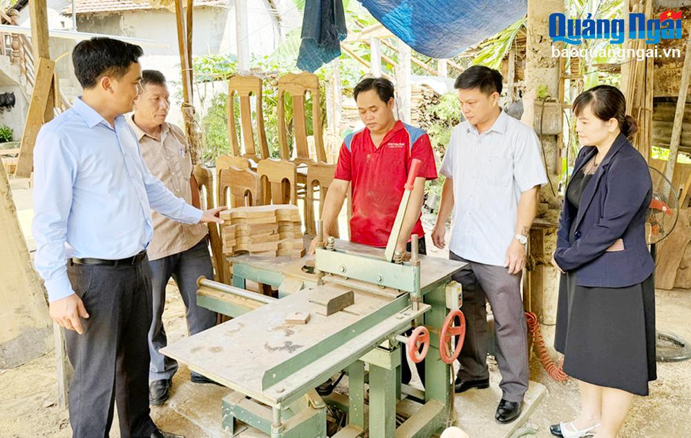 Bí thư Huyện ủy Minh Long Nguyễn Mạnh Thái (bên trái) thăm xưởng mộc của anh Đinh Văn Móp,
ở thôn An Phương, xã Thanh An sau khi được hỗ trợ mua máy làm mộc.           Ảnh: THANH THUẬN