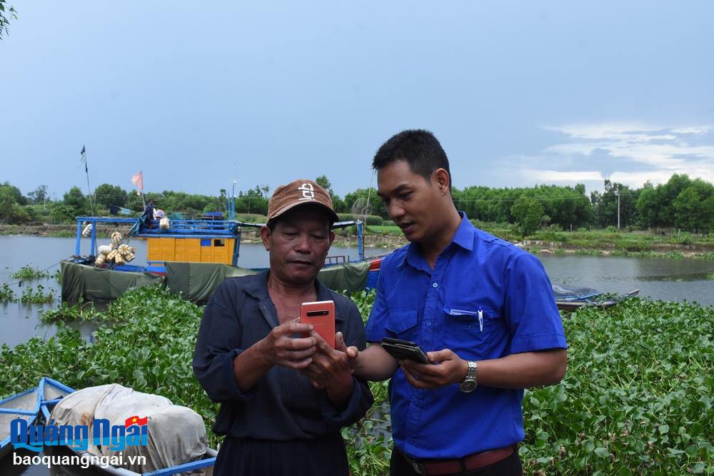 Tổ phó Tổ Công nghệ số cộng đồng xã Nghĩa phú Đặng Trung Giang đi cơ sở, hỗ trợ người dân thực hiện ứng dụng sô ngay sau Lễ phát động. (Ảnh: Ý THU)