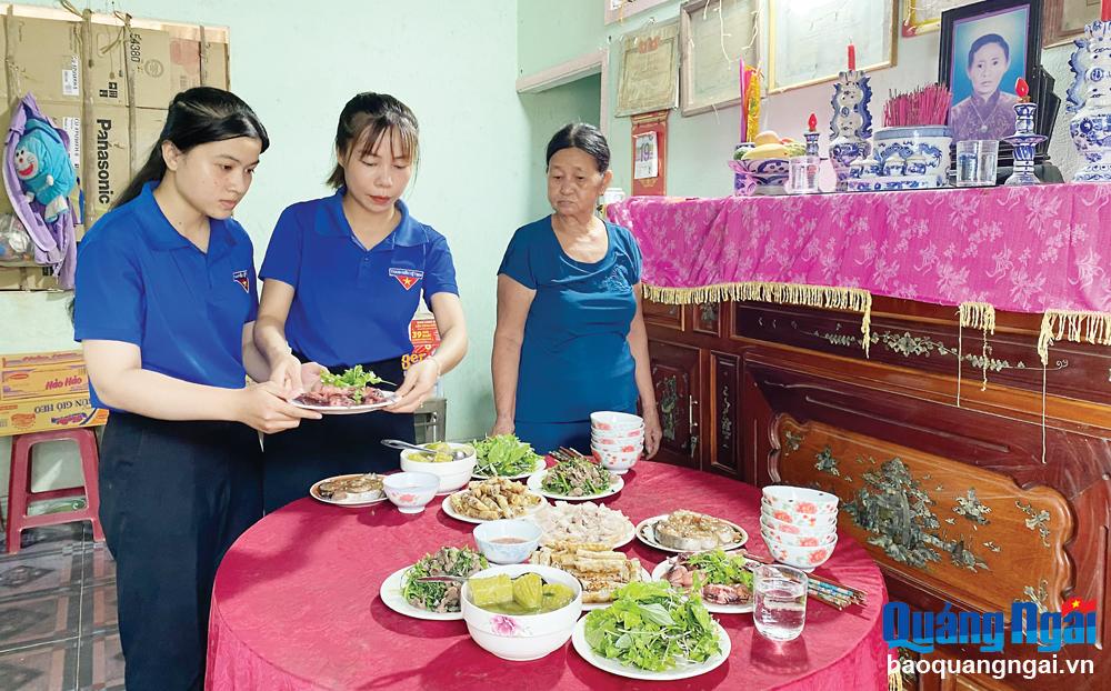 Bà Võ Thị Biên (bên phải) cùng đoàn viên, thanh niên xã Bình Hòa (Bình Sơn) chuẩn bị bữa cơm tri ân các liệt sĩ.     
