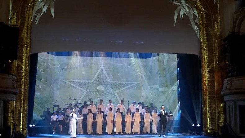 NSND Quốc Hưng và ca sĩ thiếu nhi Khánh Chi trình bày Tiến quân ca. (Ảnh chụp màn hình)