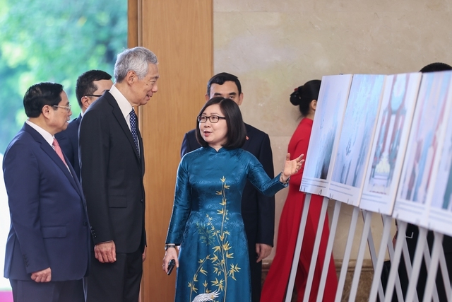 Thủ tướng Phạm Minh Chính và Thủ tướng Singapore Lý Hiển Long xem trưng bày ảnh về quan hệ hợp tác giữa Việt Nam và Singapore - Ảnh: VGP/Nhật Bắc