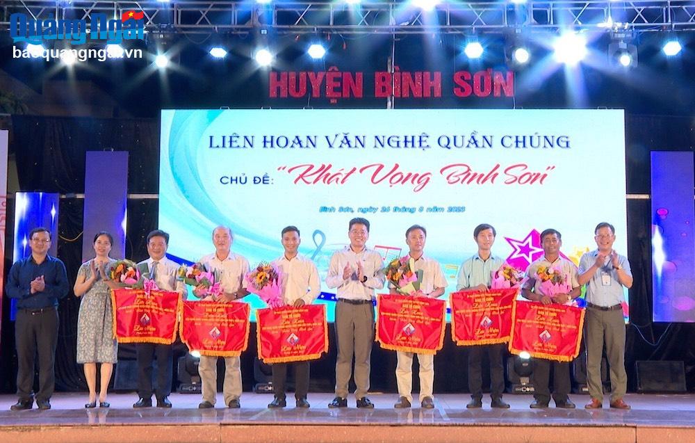 Lãnh đạo huyện Bình Sơn trao cờ lưu niệm cho các đơn vị tham gia liên hoan.