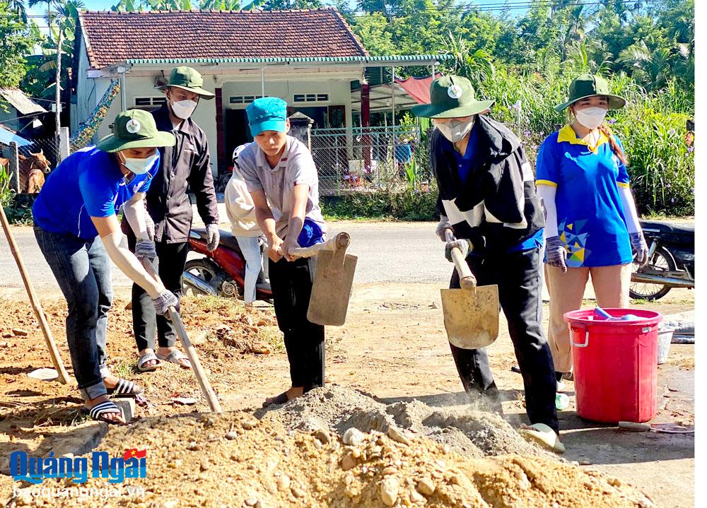 Đoàn viên, thanh niên cơ quan Đại học Đà Nẵng tham gia làm nền sân tại Trường Mầm non xã Trà Bình (Trà Bồng).                             Ảnh: Chí Dũng