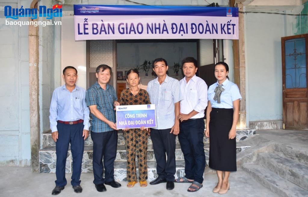 Tổng Biên tập Báo Quảng Ngãi Nguyễn Phú Đức và đại diện chính quyền địa phương trao bảng tượng trưng bàn giao nhà đại đoàn kết cho bà Lý Thị Thấp.