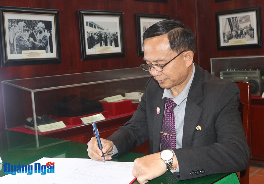 Ủy viên Ban Thường vụ Tỉnh ủy, Chủ tịch Ủy ban Mặt trận Lào xây dựng đất nước tỉnh Attapeu Bun Hôm - Phôm Mă Sản ghi vào sổ lưu niệm.
