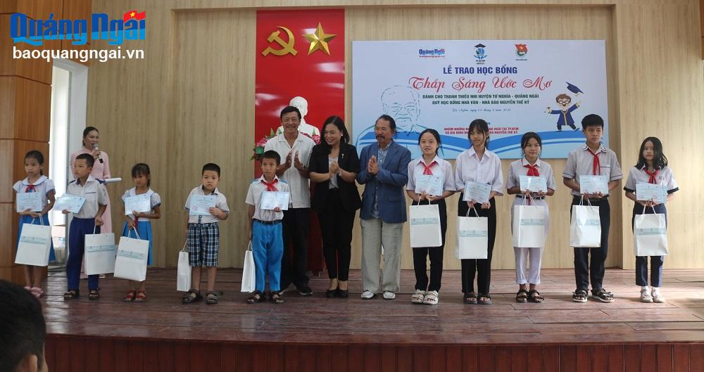 Con gái cố Nhà văn - Nhà báo Nguyễn Thế Kỷ Nguyễn Thị Hải Hằng (áo đen) và những người bạn trao học bổng cho học sinh.