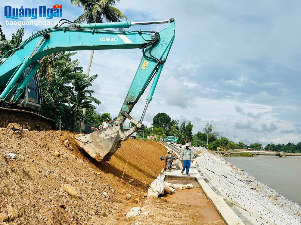 Từ chiều 17/9, tại công trường kè chống sạt lở bờ sông Trà Bồng, đoạn qua xã Bình Minh (Bình Sơn), nhà thầu vừa thi công vừa thu dọn vật dụng, vật cản quanh công trình để đảm bảo an toàn. 				   Ảnh: MỸ HOA