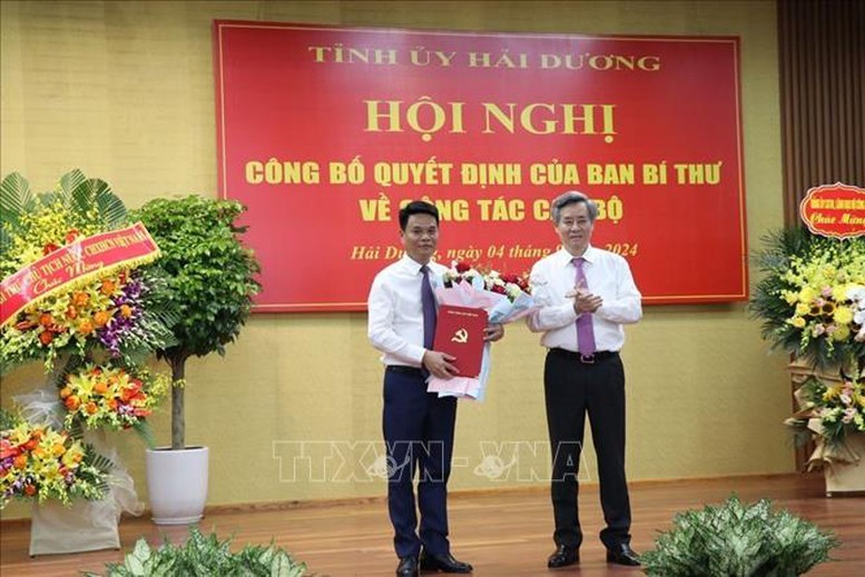 Phó Trưởng Ban Tổ chức Trung ương Nguyễn Quang Dương trao Quyết định của Ban Bí thư và tặng hoa chúc mừng đồng chí Lê Ngọc Châu - Ảnh: TTXVN