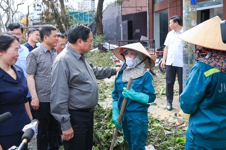 Thủ tướng thăm, động viên công nhân vệ sinh môi trường đang làm nhiệm vụ - Ảnh: VGP/Nhật Bắc