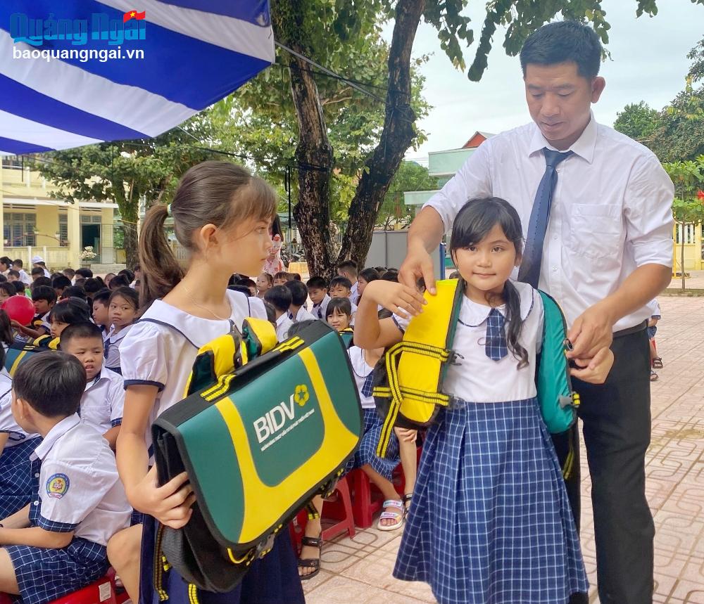 Giáo viên Trường Tiểu học Hành Tín Tây (Nghĩa Hành) hướng dẫn học sinh mang cặp phao cứu sinh.