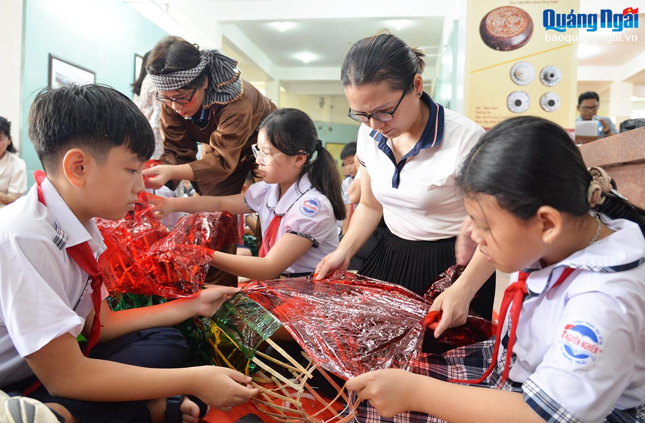 Các giáo viên hướng dẫn, hỗ trợ các học sinh làm lồng đèn.