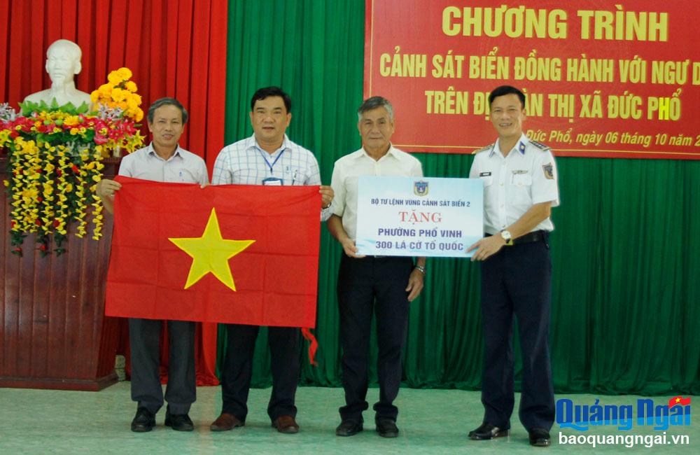 Đại tá Trần Hồng Quế - Phó Chính ủy Bộ Tư lệnh Vùng CSB 2 tặng cờ ngư dân phường Phổ Vinh