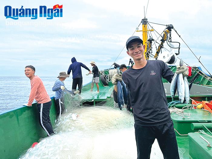 Thuyền viên Nguyễn Văn Thái, tàu lưới rê phấn khởi bên mẻ cá chuồn vừa đánh bắt được.
