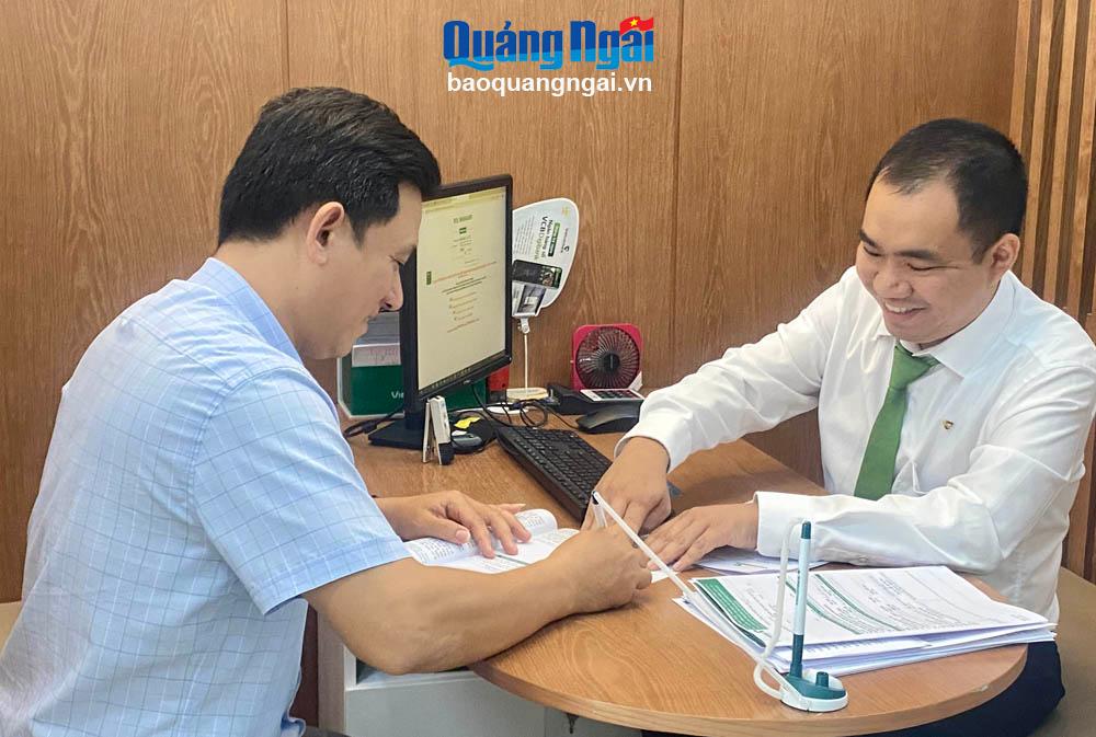 Cán bộ Phòng Giao dịch Vietcombank Hùng Vương (TP. Quảng Ngãi) hướng dẫn khách hàng hoàn thiện hồ sơ vay vốn.