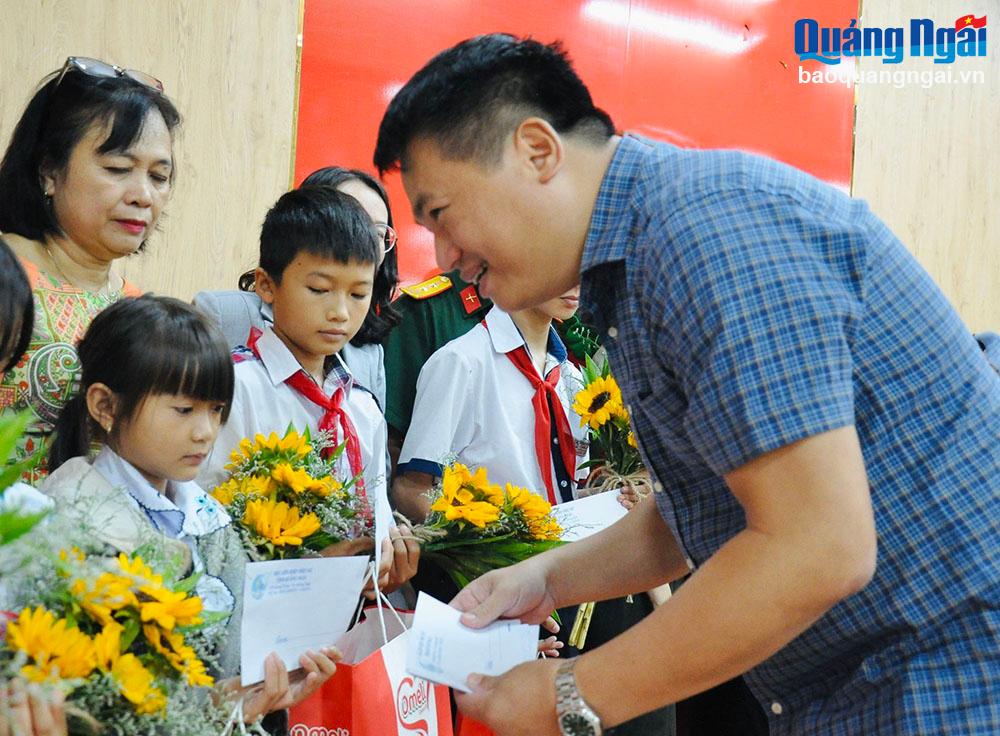 Phó Bí thư Thường trực Tỉnh ủy, Trưởng đoàn ĐBQH tỉnh Đặng Ngọc Huy trao quà cho các em mồ côi.
