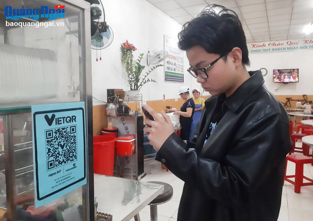Người dân thanh toán tiền qua mã QR tại quán Bánh cuốn nóng Cô Hiền (Hà) trên đường Nguyễn Tự Tân (TP.Quảng Ngãi).