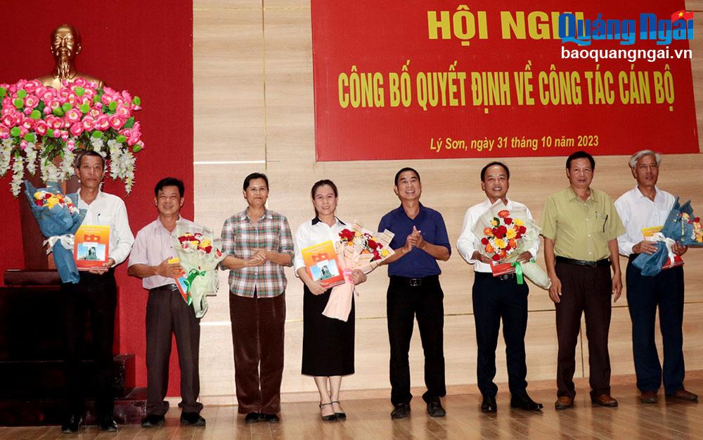 Lãnh đạo huyện Lý Sơn trao quyết định và tặng hoa chúc mừng các đồng chí điều động, bổ nhiệm.
