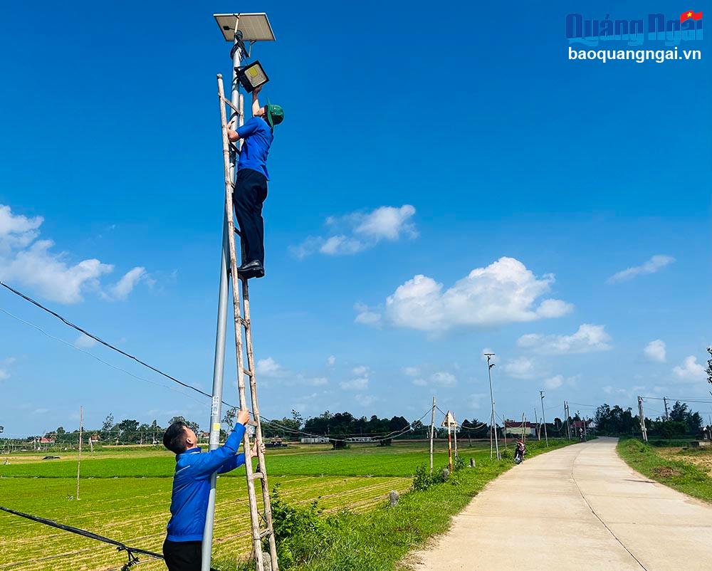 Cán bộ, đoàn viên xã Đức Thạnh (Mộ Đức) kiểm tra, bảo trì bóng đèn trên một tuyến đường.
