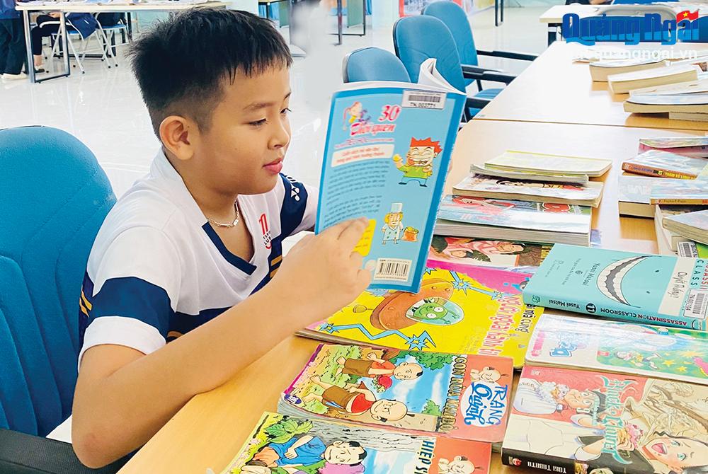 Em Cao Trần Đăng Khoa, học sinh lớp 4A, Trường Tiểu học Nguyễn Nghiêm (TX. Đức Phổ) thường xuyên đến thư viện đọc sách.