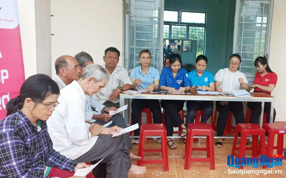 Tổ công nghệ số cộng đồng thôn Điền Hòa, xã Nghĩa Điền (Tư Nghĩa) hỗ trợ người dân sử dụng tài khoản Viettel Money.                                                      Ảnh: PV
