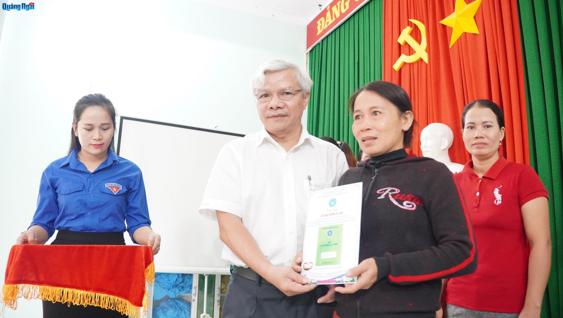 Giám đốc BHXH tỉnh Tiêu Sinh trao sổ bảo hiểm xã hội cho người dân. 