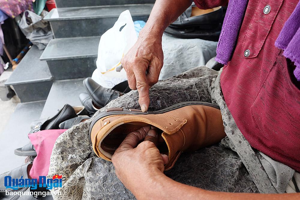 Đôi bàn tay ông Nguyễn Lai luồn từng đường kim, mũi chỉ để may lại giày cho khách.      Ảnh: BẢO HÒA