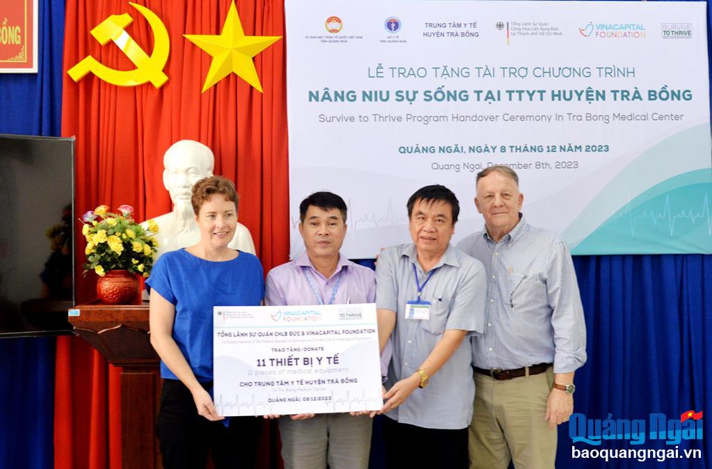 Tổng Lãnh sự Cộng hòa Liên bang Đức tại TP.Hồ Chí Minh và Giám đốc tổ chức VinaCapital trao bảng tượng trưng tặng thiết bị y tế cho Trung tâm Y tế huyện Trà Bồng.