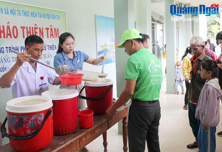 Cựu chiến binh Nguyễn Quang Thế (bên trái) phát cháo miễn phí cho bệnh nhân nghèo ở Trung tâm Y tế huyện Sơn Tây.
