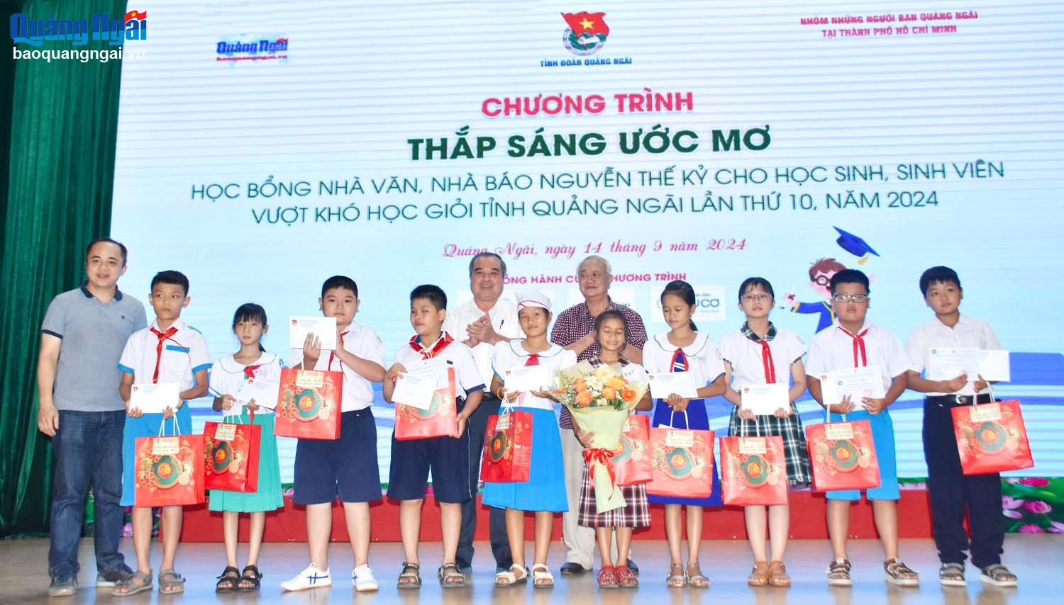 Phó Chủ tịch Thường trực UBND tỉnh Trần Hoàng Tuấn và đại diện Nhóm những người bạn Quảng Ngãi tại TP.Hồ Chí Minh trao học bổng cho các em học sinh. 