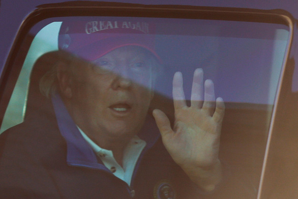 Tổng thống Mỹ Trump vẫy tay chào người ủng hộ khi đoàn xe đi ngang dòng người xuống đường ở Washington ngày 14-11 - Ảnh: REUTERS
