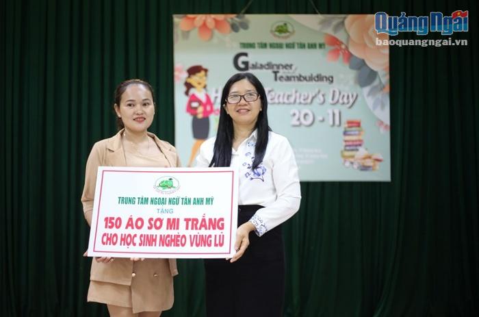 Giám đốc Trung tâm ngoại ngữ Tân Anh Mỹ Huỳnh Thị Thu Vân trao 150 áo trắng cho các em học sinh vùng bão lũ.