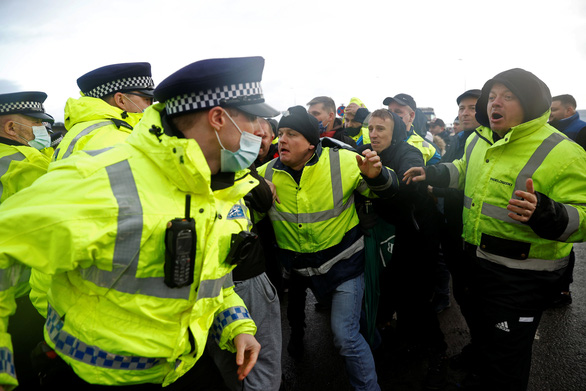 Các cảnh sát xô đẩy với các tài xế tại cảng Dover của Anh ngày 23-12-2020 khi họ đang cố ngăn không cho xe tải rời cảng và phong tỏa khu vực này cho tới khi chúng được phép rời châu Âu. Các nước EU đang cấm đi lại từ Anh sau khi phát hiện biến thể virus corona mới - Ảnh: REUTERS