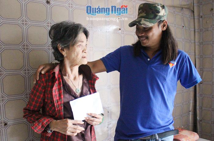 Anh Bùi Tá Thường, xã Bình Hải (Bình Sơn) hỏi thăm, trao tiền hỗ trợ cho một cụ già neo đơn ở địa phương.    ẢNH: H.CHÂU