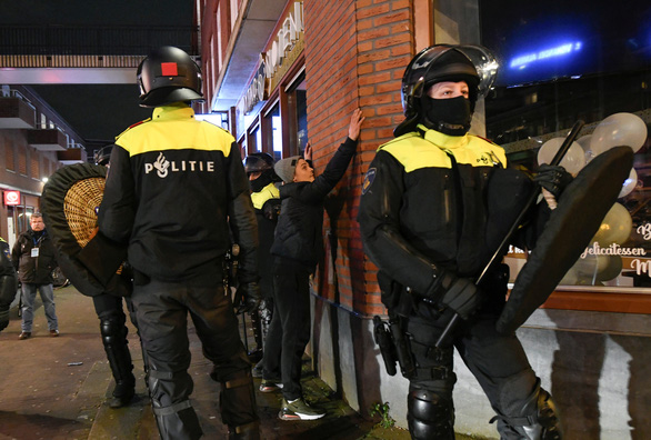 Cảnh sát chống bạo động trấn áp những người biểu tình ở TP Rotterdam tối 26-1 - Ảnh: REUTERS