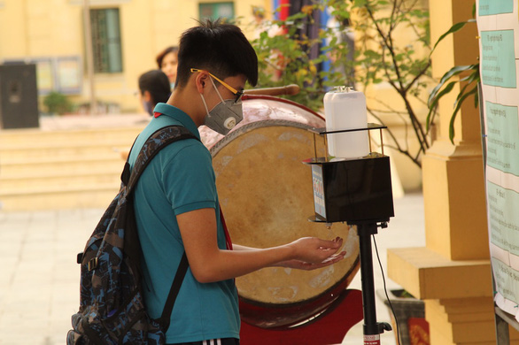 Học sinh Trường THCS Trưng Vương (Hà Nội) sát khuẩn tay trước khi vào trường - Ảnh: CHU HÀ LINH