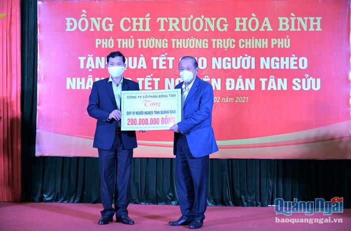 Phó Thủ tướng Thường trực Chính phủ Trương Hòa Bình trao bảng tượng trưng số tiền 200 triệu đồng từ Công ty CP Đồng tâm tặng cho Quỹ vì người nghèo tỉnh Quảng Ngãi