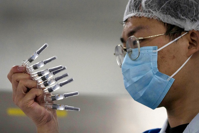 Nhân viên kiểm tra ống đựng vắc xin Sinovac tại Bắc Kinh, Trung Quốc. (Ảnh: LA Times)