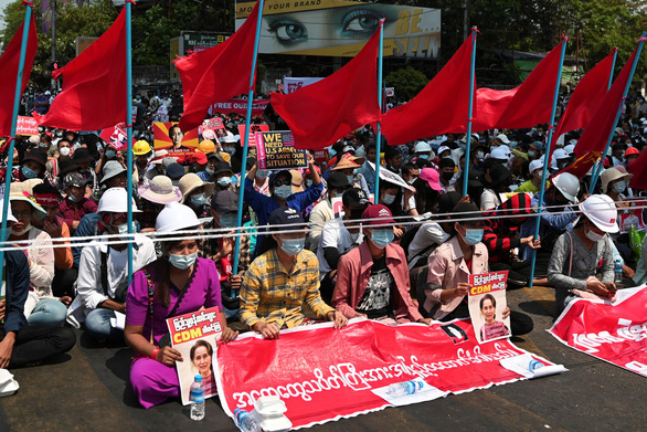 Người dân Myanmar mang theo cờ và biểu ngữ trong cuộc biểu tình phản đối đảo chính ở Yangon, thành phố lớn nhất Myanmar, ngày 20-2 - Ảnh: REUTERS
