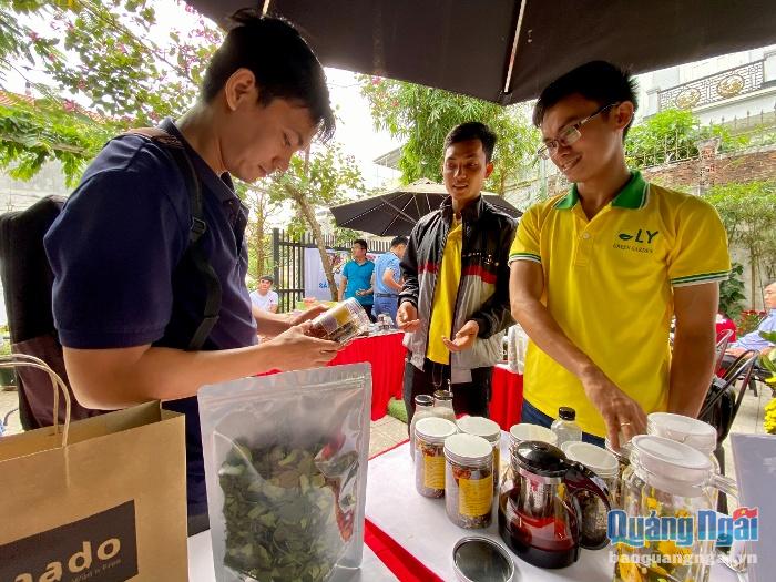 Anh Bạch Thanh Phú (ngoài cùng bên phải) giới thiệu sản phẩm trà gạo thảo mộc đến người tiêu dùng.