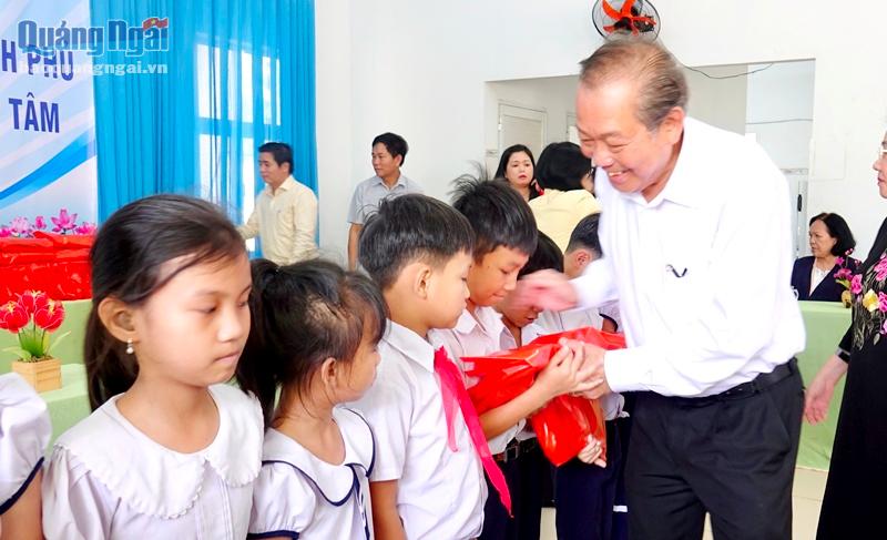 Phó Thủ tướng Thường trực Chính phủ Trương Hòa Bình động viên và tặng quà cho các cháu học sinh tại Trung tâm