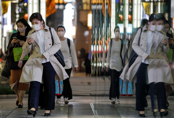 Người dân đeo khẩu trang khi đi lại trên đường phố ở thủ đô Tokyo ngày 22-4 trong bối cảnh dịch bệnh đang bùng phát trở lại tại Nhật Bản - Ảnh: REUTERS